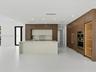 Kitchen featuring wood-finish cabinetry, central island with stone-surface countertop, built-in double wall oven, integrated refrigerator paneling, an