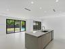 Open-concept interior featuring an expansive kitchen island with stone-finish countertops, undermount sink, and integrated beverage refrigeration