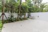 Private outdoor patio featuring light-toned tile flooring, built-in cabinetry with a sink, stainless steel grill, solid privacy walls, and mature peri
