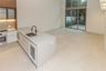 Kitchen featuring a stone-surface island, built-in wine refrigeration, high-ceiling glass sliding doors, and large-format tile flooring