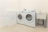 Utility area featuring a deep-basin laundry sink with a dual-handle faucet and dedicated washer and dryer connections