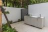 Outdoor kitchen area featuring large-format tile flooring, a stone-finish countertop, stainless steel integrated grill, undermount sink, and privacy w