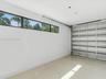Finished garage featuring epoxy flooring, horizontal clerestory windows, and a metal sectional overhead door
