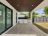 Covered patio featuring large-format stone-finish tile flooring, slatted wood-tone ceiling, recessed lighting, and a built-in outdoor kitchen with a s