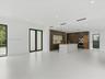 Open-concept interior featuring large-format tile flooring, a kitchen island with a stone-finish countertop, dark wood-finish cabinetry, built-in stai