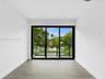 Multi-panel sliding glass doors with black frames, wood-finish flooring, recessed lighting, and a glass-paneled balcony railing