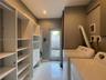 Custom built-in white shelving system with integrated storage drawers, polished tile flooring, and glass-paneled exterior door