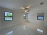 Polished large-format tile flooring, recessed lighting, ceiling fan with integrated lighting, and multiple windows with roller shades