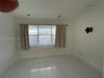 Large-format tile flooring, recessed ceiling lighting, and a multi-pane horizontal window featuring a metal curtain rod