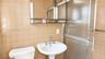 Wall-mounted medicine cabinet with integrated shelving, pedestal sink, metallic widespread faucet, and shower enclosure with textured glass doors, set