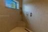 Walk-in shower featuring floor-to-ceiling mosaic tile, built-in corner bench, dual-recessed wall shelving, linear floor drain, and wall-mounted hand-h