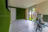 Room featuring textured green wall cladding, neutral large-format tile flooring, recessed ceiling lighting, and sliding glass doors with exterior acce