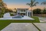 Modern exterior featuring a two-story flat roofline, integrated swimming pool with tiled spa, large-format porcelain patio pavers, and minimalist conc