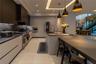 Modern kitchen featuring custom flat-panel cabinetry, dark stone-finish countertops, built-in stainless steel appliances, a large central island with 