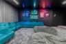 Media room featuring a matte black ceiling and accent wall, integrated track lighting, and full-height floor-to-ceiling drapery