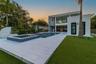Modern exterior featuring a two-story architectural design, private swimming pool with integrated spa, large-format tile decking, and a maintained art