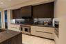 Modern kitchen featuring two-tone custom cabinetry, dark stone-finish countertops and backsplash, stainless steel gas range with pot filler, and built