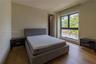 Neutral-toned bedroom featuring wood-finish flooring, a large window with black framing, and recessed lighting