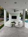 Covered patio featuring large-format porcelain tile flooring, recessed lighting, ceiling fan, and a mounted wall display
