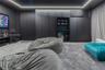 Floor-to-ceiling matte black cabinetry, integrated shelving unit with a built-in beverage refrigerator, cove ceiling lighting, and wall-to-wall carpet