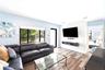 Living area featuring wood-finish flooring, recessed lighting, a large picture window, and a built-in floating media console