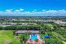 Recreational facilities featuring two hard-court tennis courts, a swimming pool with paved deck, and a shaded structure