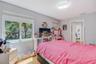 Bedroom featuring wood-finish flooring, dual-pane windows, and a flush-mount overhead light fixture