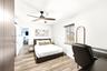 Wood-finish flooring, ceiling fan with integrated light, horizontal window blinds, and interior doors