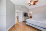 Vaulted ceilings, wood-finish flooring, and a decorative leaf-style ceiling fan