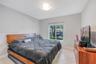 Neutral-toned walls, tile flooring, flush-mount ceiling lighting, and a window with a horizontal blind