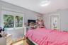 Bedroom featuring wood-finish flooring, dual-pane windows, and a semi-flush mount light fixture