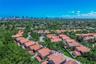 Aerial perspective featuring low-density residential neighborhood architecture, clay tile roofing, and prominent urban skyline horizon
