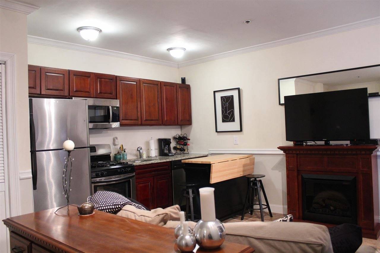 Unique studio condo featuring elegant cherry kitchen cabinets with granite counters