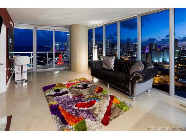 Corner sky residence features floor-to-ceiling windows throughout overlooking stunning views of Biscayne Bay