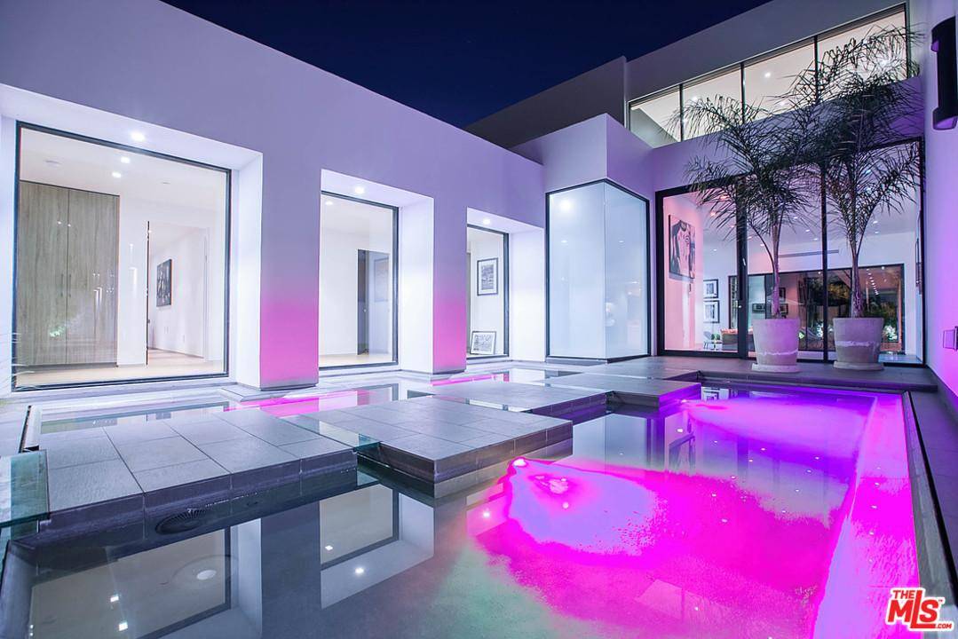 Walk on water through a perfectly landscaped front yard to enter an entertainer's paradise