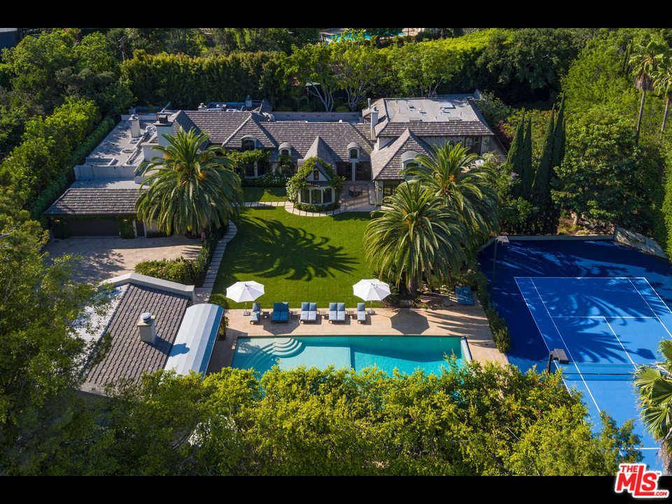 An impressive tree-lined private driveway leads to a French country estate in prime A plus location in the heart of Beverly Hills