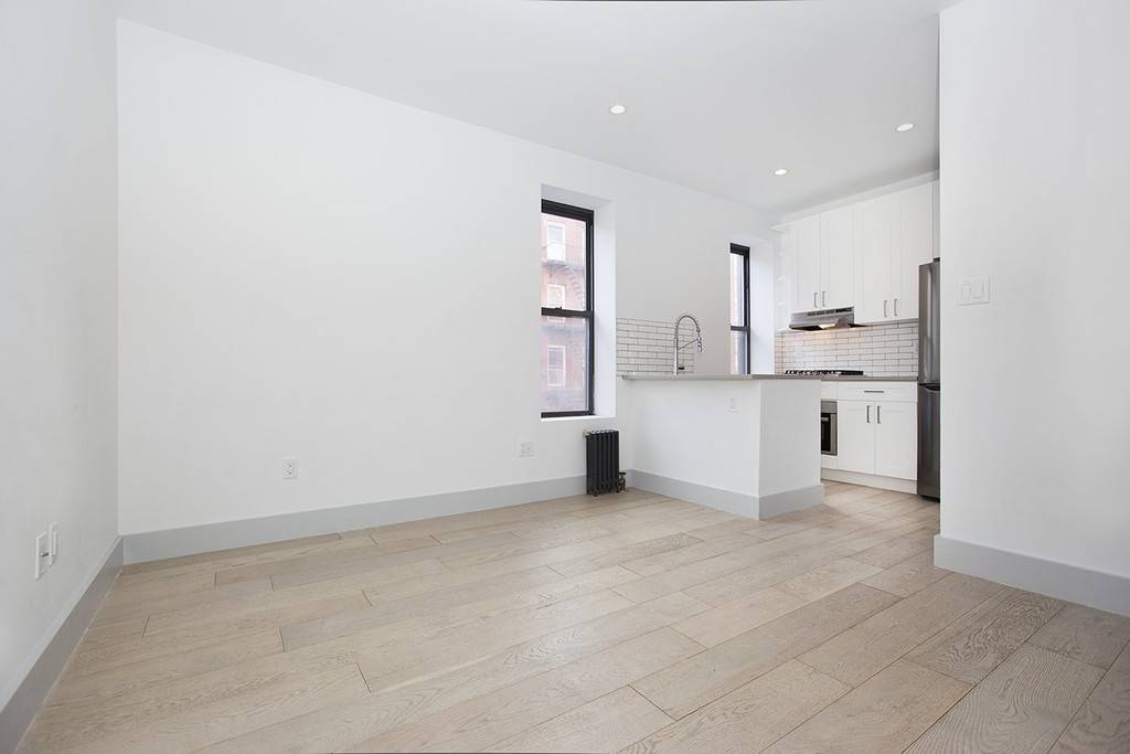 Newly Renovated Three Bedroom in Prime East VillageLarge living room with open kitchen featuring stainless steel appliances including an LG refrigerator, Bosch dishwasher, range and oven as well as stone ...