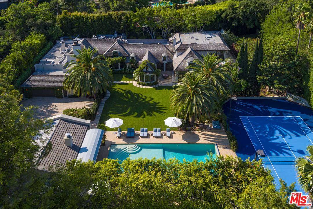 An impressive tree-lined private driveway leads to a French country estate in prime A plus location in the heart of Beverly Hills