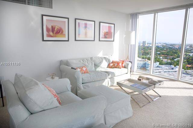 This spacious furnished unit with an open floor plan has two bedroom/two full bathrooms and a half bath with floor to ceiling windows