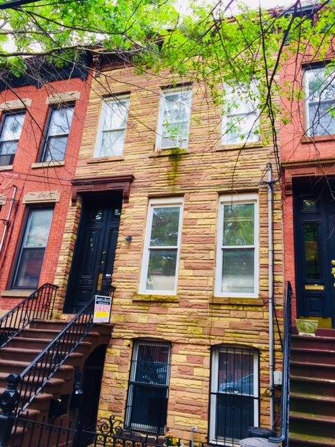 Spacious two bed two bath duplex in a brick row house with lovely private yard and deck in the Van Vorst section of downtown JC