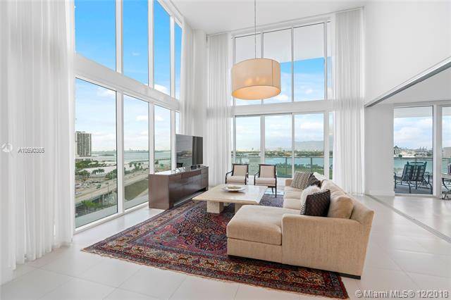 Expansive 20+ ft ceilings framing Miami water views from this 2BD & 2