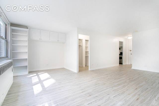 Featuring gorgeous updates and an expansive floor plan, this lovely and bright alcove studio apartment is the perfect Lenox Hill retreat in a full service postwar co op building.