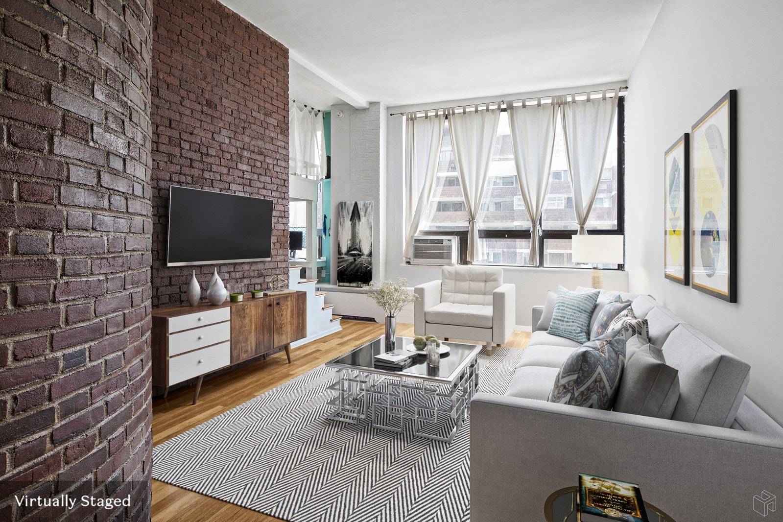 This incredibly spacious alcove loft studio apartment features a flexible floor plan featuring soaring 11 foot ceilings and exposed brick walls.