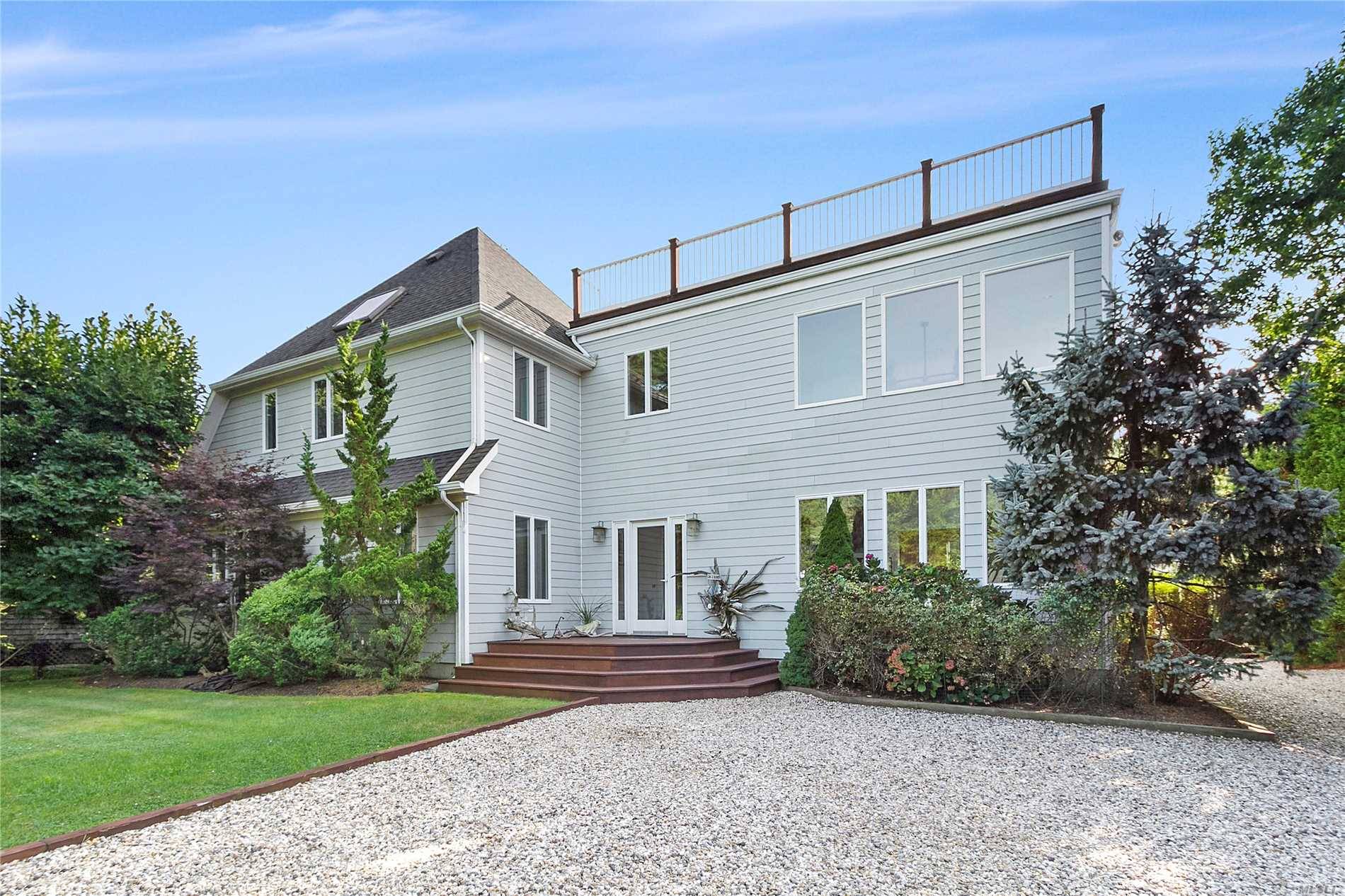 This double lot, double height modern home is tucked away in Amagansett North, 4 lots from the Gardiner Bay beach access.