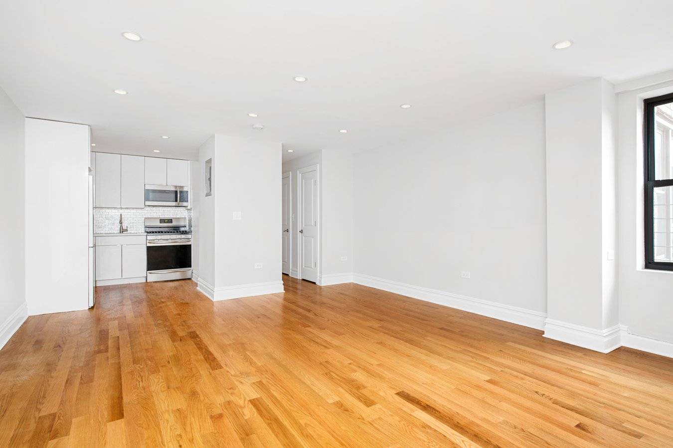 Modern, gut renovated studio apartment featuring new oak hardwood floors, separate kitchen with Quartz counter tops, stainless steel appliances and a glass tiled back splash.