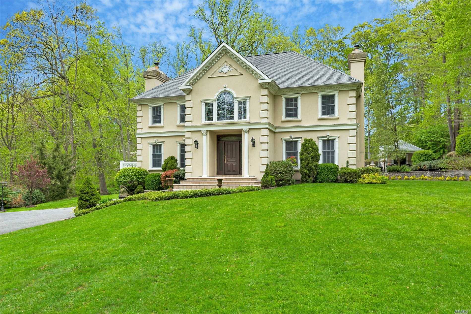 LATTINGTOWN. Stately Young Stucco Colonial Set On Over 2 Private and Serene Acres In Lattingtown.