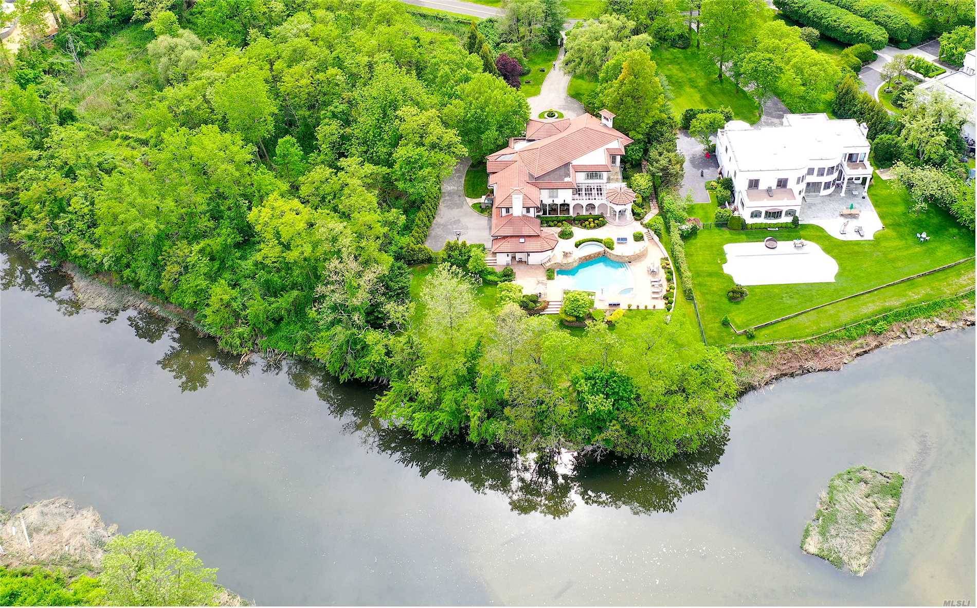 Stunning waterfront Mediterranean style home on approximately 1 acre of beautifully manicured property in the heart of prestigious Kings Point.