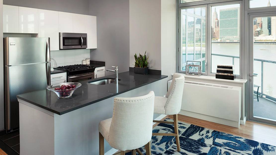 No Fee Long Island City One Bedroom Apartment with Featuring High Ceilings, an Entryway Home Office, Open Kitchen, and Spacious Living/Dining Area with Beautiful Partial Water Views