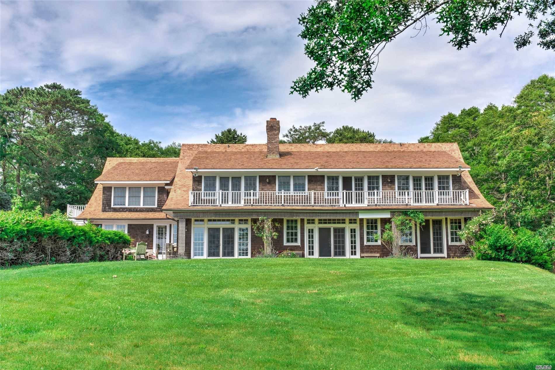Indulge in Hamptons luxury living and ultimate privacy in East Quogue at this 2.