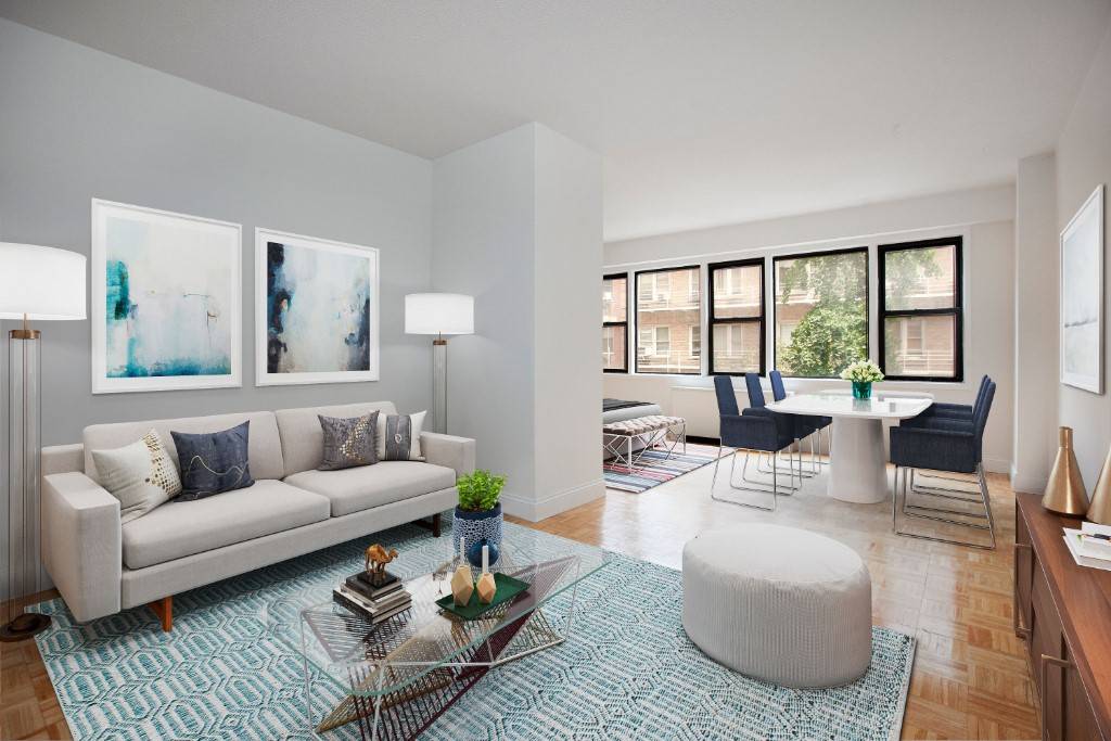 Bright and airy turnkey alcove studio in Yorkville featuring a wall of windows, renovated kitchen and bathroom, hardwood floors, and abundant closet space.